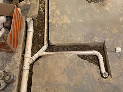 Underground PVC plumbing pipe rough-in installation for a basement bathroom remodel