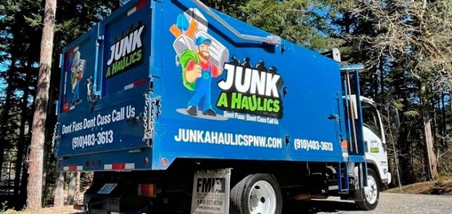 Rear view of a large blue Junk A Haulics junk removal truck featuring a cartoon mascot logo, website URL, and phone number.