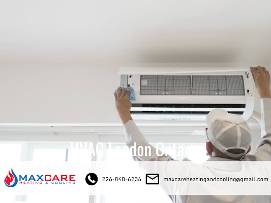 A technician adjusting an AC unit on the wall.