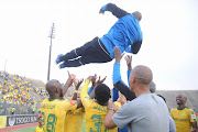 Mamelodi Sundowns players lift their coach Pitso Mosimane in celebrations.