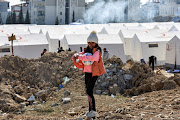 A girl holding sports balls stands at a camp for survivors, in the aftermath of the deadly earthquake, in Adiyaman, Türkiye.