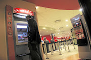 A man withdraws cash from an Absa ATM  in Johannesburg.