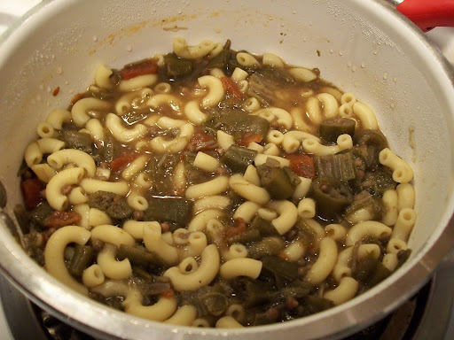 A bowl of okra, tomatoes and onion cooked in chicken broth .