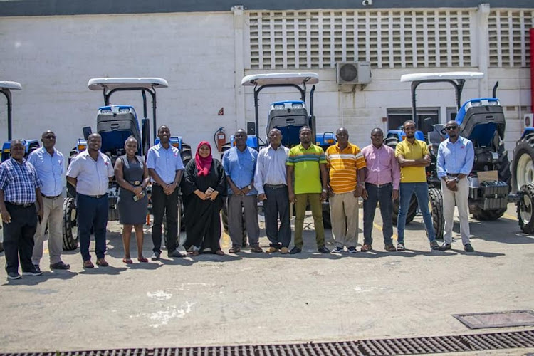 County officials pose with some of the new tractors purchased by the county government of Lamu.