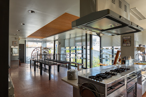 Professional kitchen with central island and tables in this luxury house for sale in Naha ($2,031,244)
