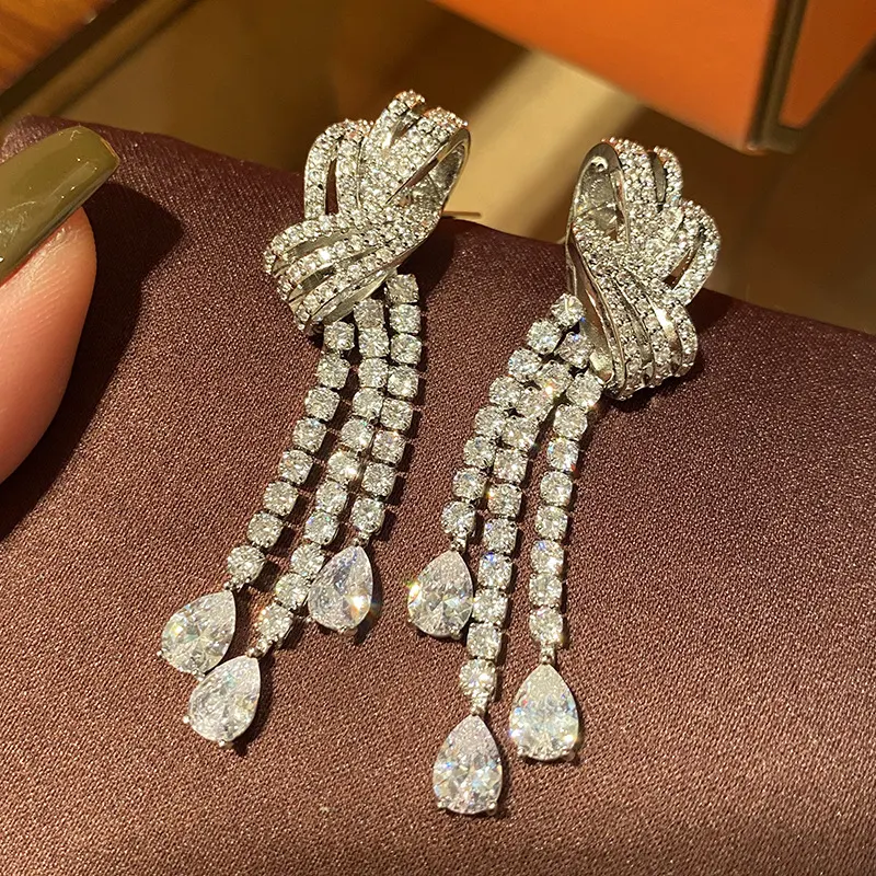 Boucles d'oreilles rétro avec nœuds, goutte d'eau et pompon. Un style unique pour compléter votre look avec une touche d'élégance intemporelle.