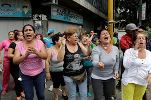 People shout at Venezuelan National Guards during riots for food in Caracas