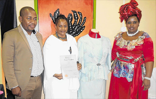 DESTINED FOR SUCCESS: Mthatha fashion designer 53-year-old Bulelwa Mgobo standing next to one of her beautiful creations and flanked by Deputy Trade and Industry Minister Mzwandile Masina and OR Tambo district municipality mayor Nomakhosazana Meth. Picture: SIKHO NTSHOBANE