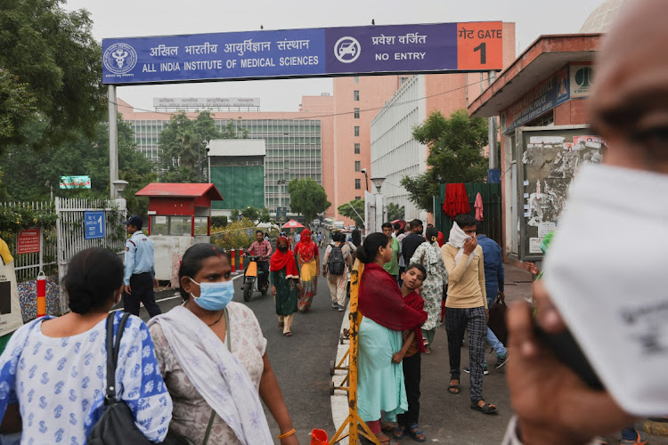 People walk across the road outside the All India Institute of Medical Sciences in New Delhi, India, on May 1 2023. Picture: REUTERS/ANUSHREE FADNAVIS