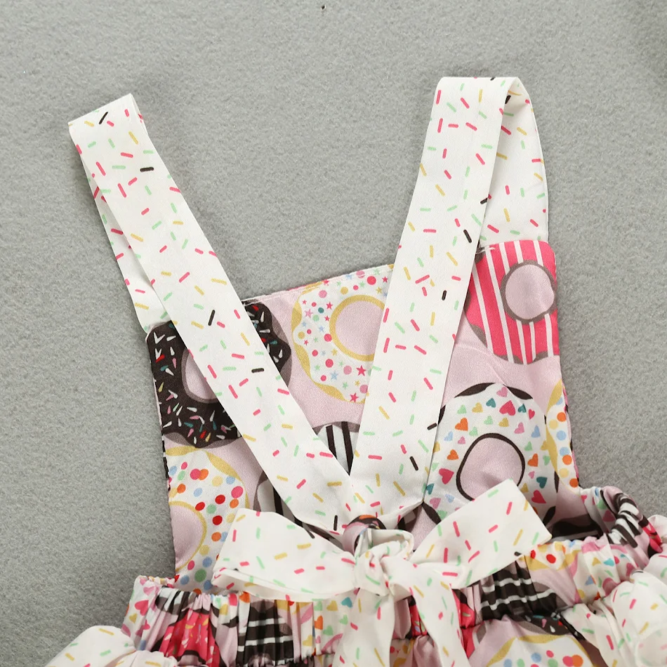 Barboteuse décontractée sans manches pour fille avec imprimé donuts. Combinaison d'été confortable et tendance pour enfants.