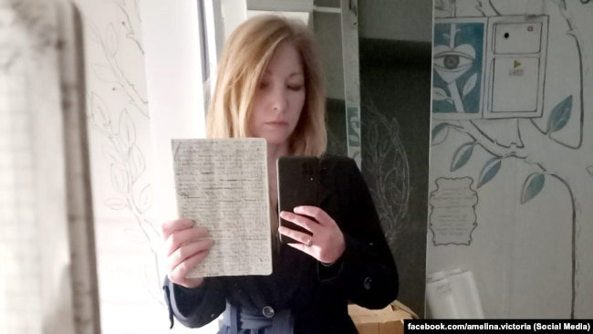 Вікторія Амеліна тримає в руках щоденник Володимира Вакуленка