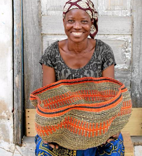 Weaver Lizzy Atinlebine poses with her one of her baskets