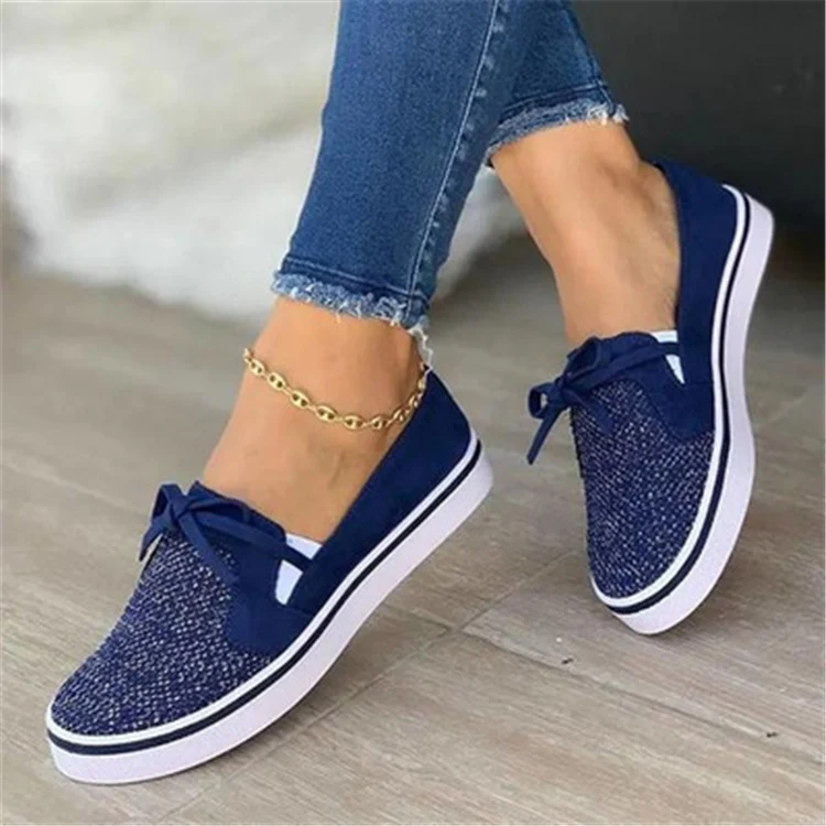 Baskets plates en toile à lacets pour femmes, sneakers blanches, confortables et tendance, idéales pour un look décontracté.