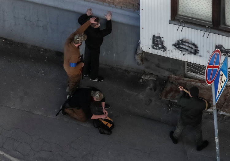 Members of the Ukrainian Territorial Defense Forces check a man as they patrol during a long curfew in Kyiv, Ukraine, March 22 2022. Picture: GLEB GARANICH/ REUTERS