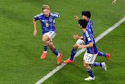 Japan's Ritsu Doan celebrates scoring their first goal with Kaoru Mitoma and Ao Tanaka.