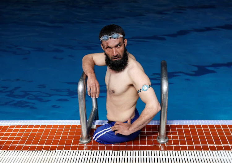 Khan Agha 28, sits in a swimming pool during his practice in Kabul, Afghanistan May 16, 2017. Picture taken May 16, 2017.