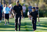 Tiger Woods and son Charlie Woods walk during the Pro-Am ahead of the PNC Championship at the Ritz Carlton Golf Club Grande Lakes  in Orlando, Florida on December 17 2021.