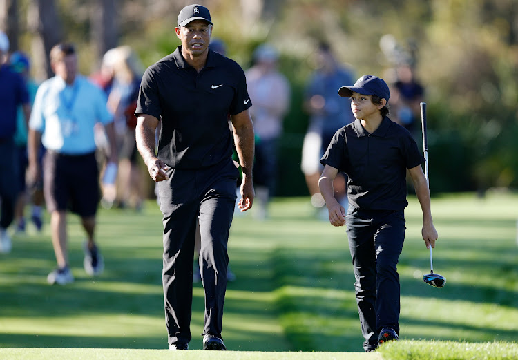 Tiger Woods and son Charlie Woods walk during the Pro-Am ahead of the PNC Championship at the Ritz Carlton Golf Club Grande Lakes in Orlando, Florida on December 17 2021.