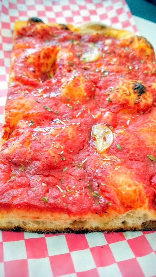 Roman Candle Baking Company offers a Roman style Pizza Bianca- here is Pomodoro with Tomato, oregano, xvoo, sea salt