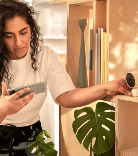 Femme configurant une caméra via son application Google Home