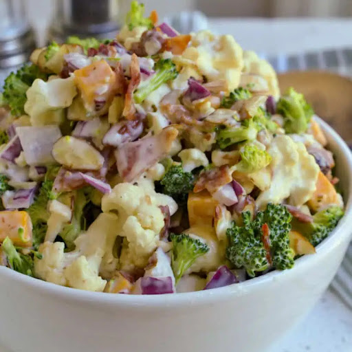 This delectable spring and summer Cauliflower Broccoli Salad with homemade dressing comes together in about twenty minutes.  It is the perfect side dish for all your grilling and barbecue recipes, with plenty of flavor and texture.
