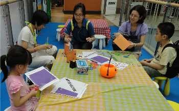 Creating activity in the library. Young children learning to create craft projects in a library.