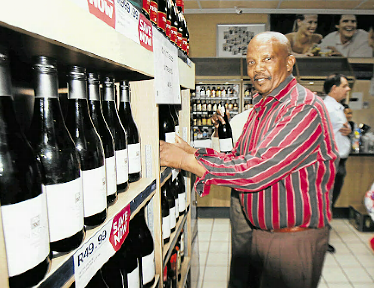 Mayime Primary Agricultural Co-operative chair Selborne Cecane packs the historical first store shelves with Inkosi wine.