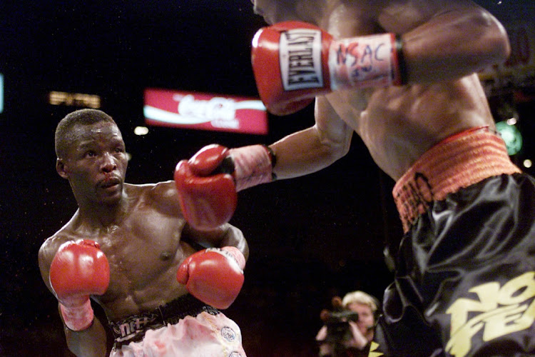 Lehlohonolo Ledwaba (L) weaves as Manny Pacquiao throws a punch during IBF Super Bantamweight Championship bout at the MGM Grand Hotel & Casino in Las Vegas, Nevada.