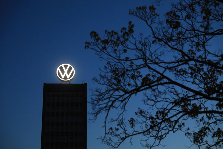 The Volkswagen logo sits illuminated on top of a building at the automaker's headquarter at dawn in Wolfsburg, Germany.