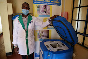 A clinical officer Gerald Yiaile stands next to an empty vaccine refrigerator at a health clinic in the town of Sekenani, Narok county, Kenya, December 1, 2021. 