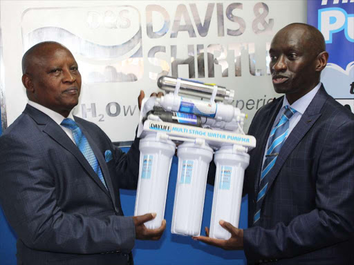 Nyeri governor Mutahi Kahiga receives a water purifier as gift from Davis and Shirtliff CEO, David Gatende, during the official opening of the company’s new branch in Nyeri town on Thursday.