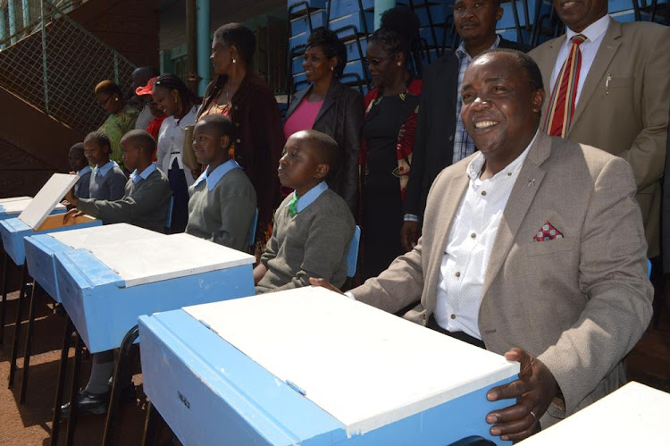 Jude Njomo Kiambu MP (Seated right) during the unveiling of new lockers which will be used in Kiambu township primary school pupils in standard seven and eight. He is in a mission of replacing old desks with lockers in all schools within the constituency