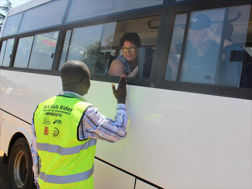 NTSA regional manager Jackson Mutua chats with a tourist during a crackdown along the Nyeri -Karatina highway on Saturday / WAMBUGU KANYI