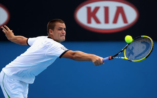 Mikhail Youzhny of Russia plays a backhand in his third round match against Milos Raonic of Canada during day six of the 2011 Australian Open at Melbourne Park on January 22, 2011 in Melbourne, Australia