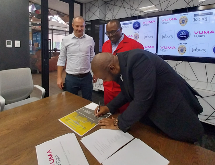 Vumacam CEO Ricky Croock , public safety MEC Mgcini Tshwaku and public safety acting head of department Tebogo Modiba sign the memorandum of understanding.