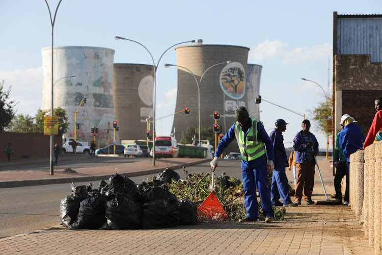 Unemployed residents clean the streets as a piece job in Bloemfontein city centre before President Cyril Ramaphosa's visit to Mangaung.