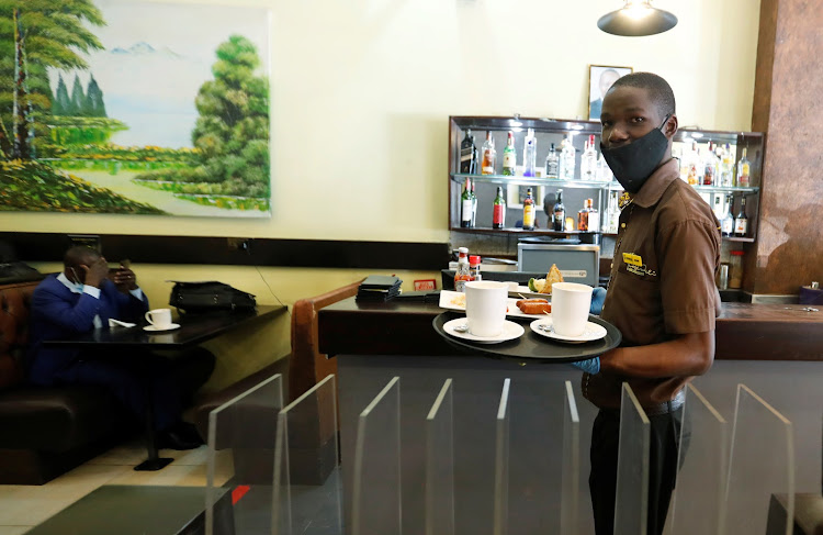 John Brian, an employee at Cafe Deli Restaurant delivers an order during the reopening after weeks of lockdown restrictions amid the coronavirus disease (COVID-19) outbreak, along Kenyatta avenue in Nairobi, Kenya June 11, 2020.