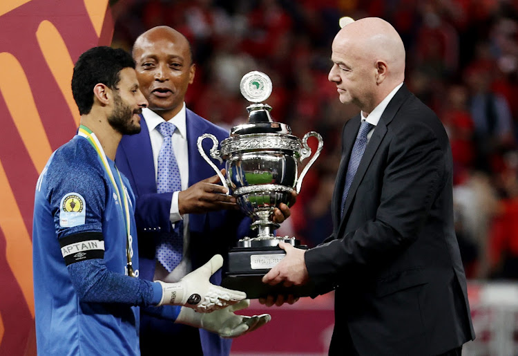 Fifa president Gianni Infantino presents Al Ahly's Mohamed El Shenawy with the African Super Cup trophy as Caf president Patrice Motsepe looks on