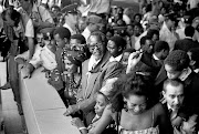  Oliver Tambo at Jan Smuts airport on December 13  1990. His wife, Adelaide, is on his left and Winnie Mandela is on his right. Son Dali is  behind him