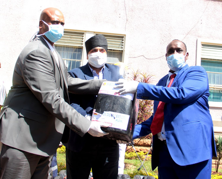 NMS director general.Mohammed Badi and Interior CAS Hussein Dado receive hand sanitisers from Chatthe