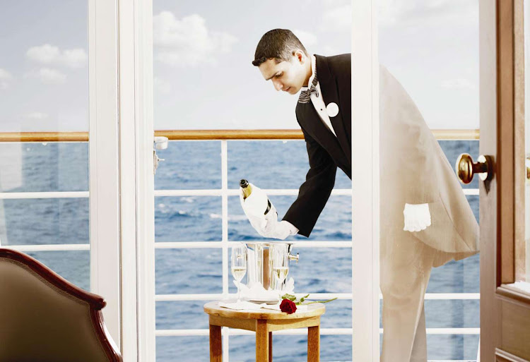 A butler on a Silversea sailing pours champagne on a guest's veranda.