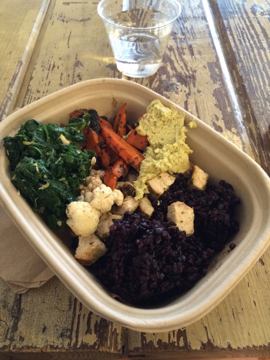 Black rice bowl with chicken, cauliflower, carrots, kale, and hummus