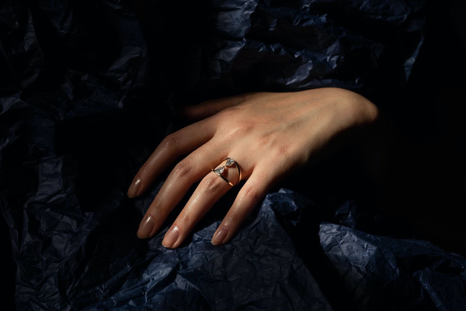 Close up of women's hand wearing a gold ring.