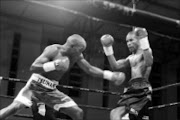 WORKING THE BODY: 'Tsunami' Taliwe, left, exchanges blows with Jasper Seroka during their SA junior lightweight title fight at Finetown Multipurpose Centre in Lenasia at the weekend. Taliwe won on points. Pic. Bafana Mahlangu. 08/11/2009. © Sowetan.