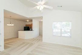 Living room overlooks dining area, kitchen and foyer space ahead