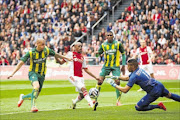 GIFTED:  Thulani Serero of Ajax tries to get his shot in while fending  off a tackle from  Vito Wormgoor of ADO Den Haag as   keeper Gino Coutinho closes in during  the Dutch Eredivisie match  at  Amsterdam Arena on Sunday. Serero scored one goal and set up another in a 3-2 win 
      Photo: VI Images via Getty Images