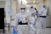 Healthcare workers wearing personal protective equipment (PPE) walk through the ward at the Seoul Medical Center in Seoul, South Korea, on Monday, Jan. 18, 2021. 