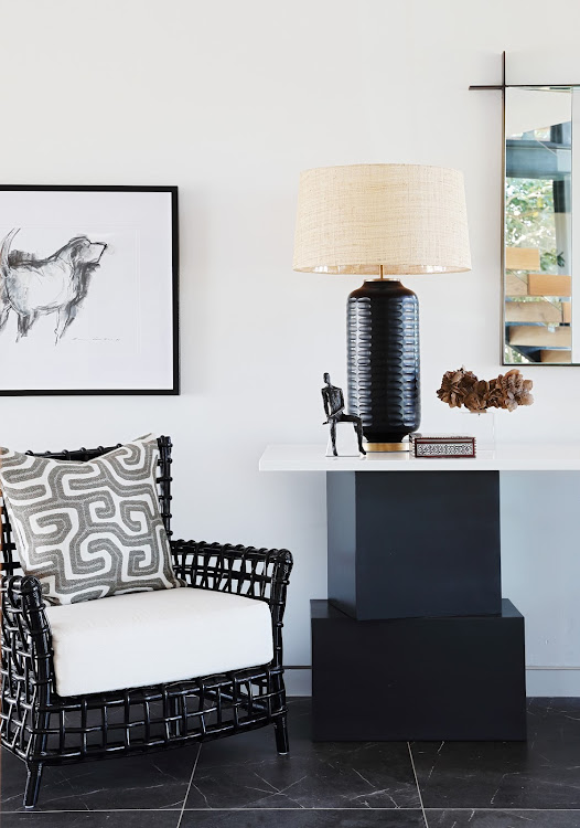 The home's striking architecture is echoed in the architectural nature of the pieces used to furnish it, such as this console table in the entrance hall.