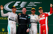 SHANGHAI, CHINA - APRIL 12:  Second placed Nico Rosberg (L) of Germany and Mercedes GP, first placed Lewis Hamilton (2nd R) of Great Britain and Mercedes GP and Sebastian Vettel (R) of Germany and Ferrari wave to the fans following the Formula One Grand Prix of China at Shanghai International Circuit on April 12, 2015 in Shanghai, China.  (Photo by Dan Istitene/Getty Images)