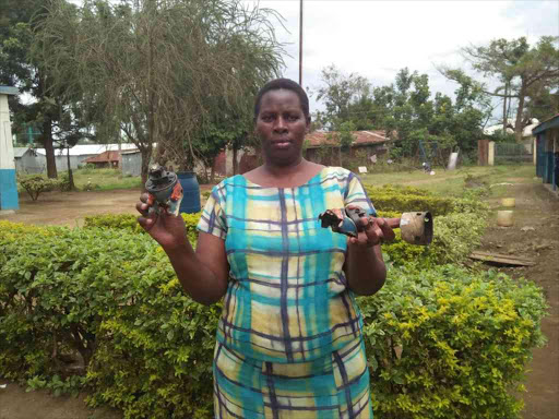 Eunice Odhiambo, head teacher of St Peter's Awich Kidingo ECDE centre in Kisumu, displays materials found after police lobbed teargas canisters, October 2, 2017. /FAITH MATETE